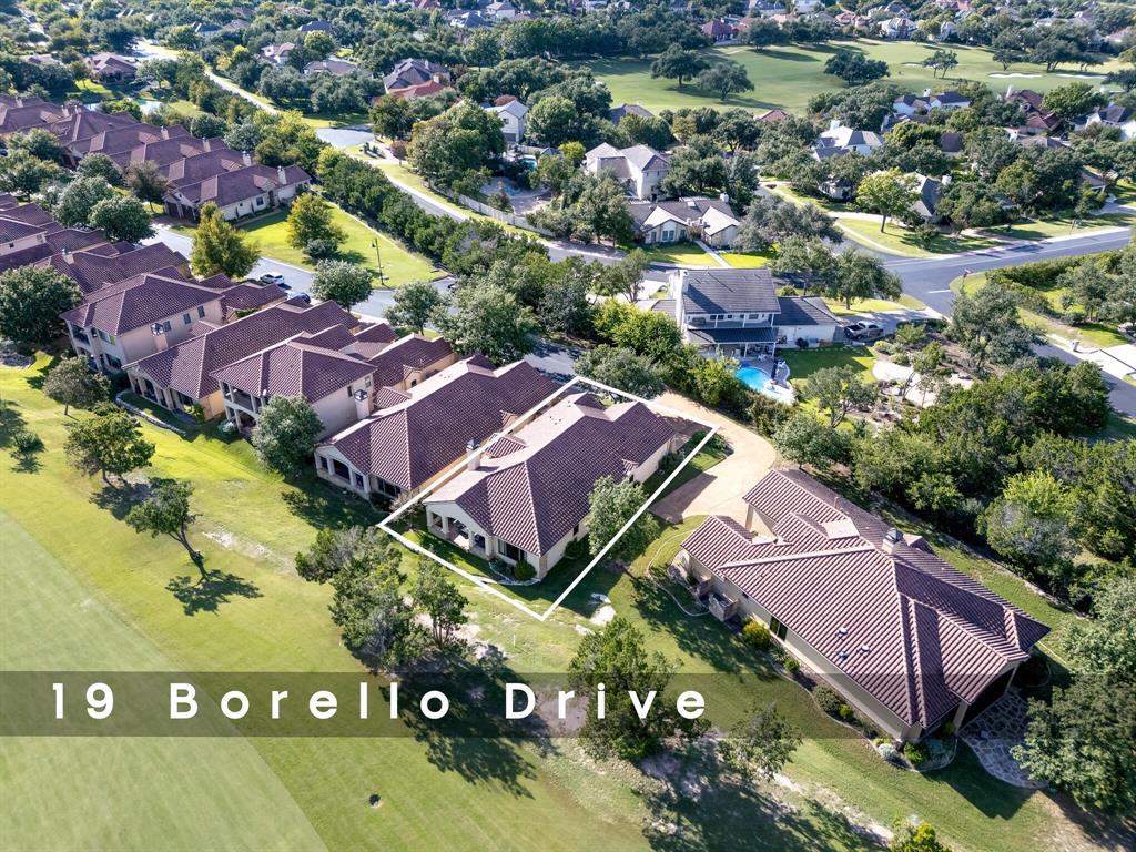 an aerial view of residential houses with outdoor space and parking