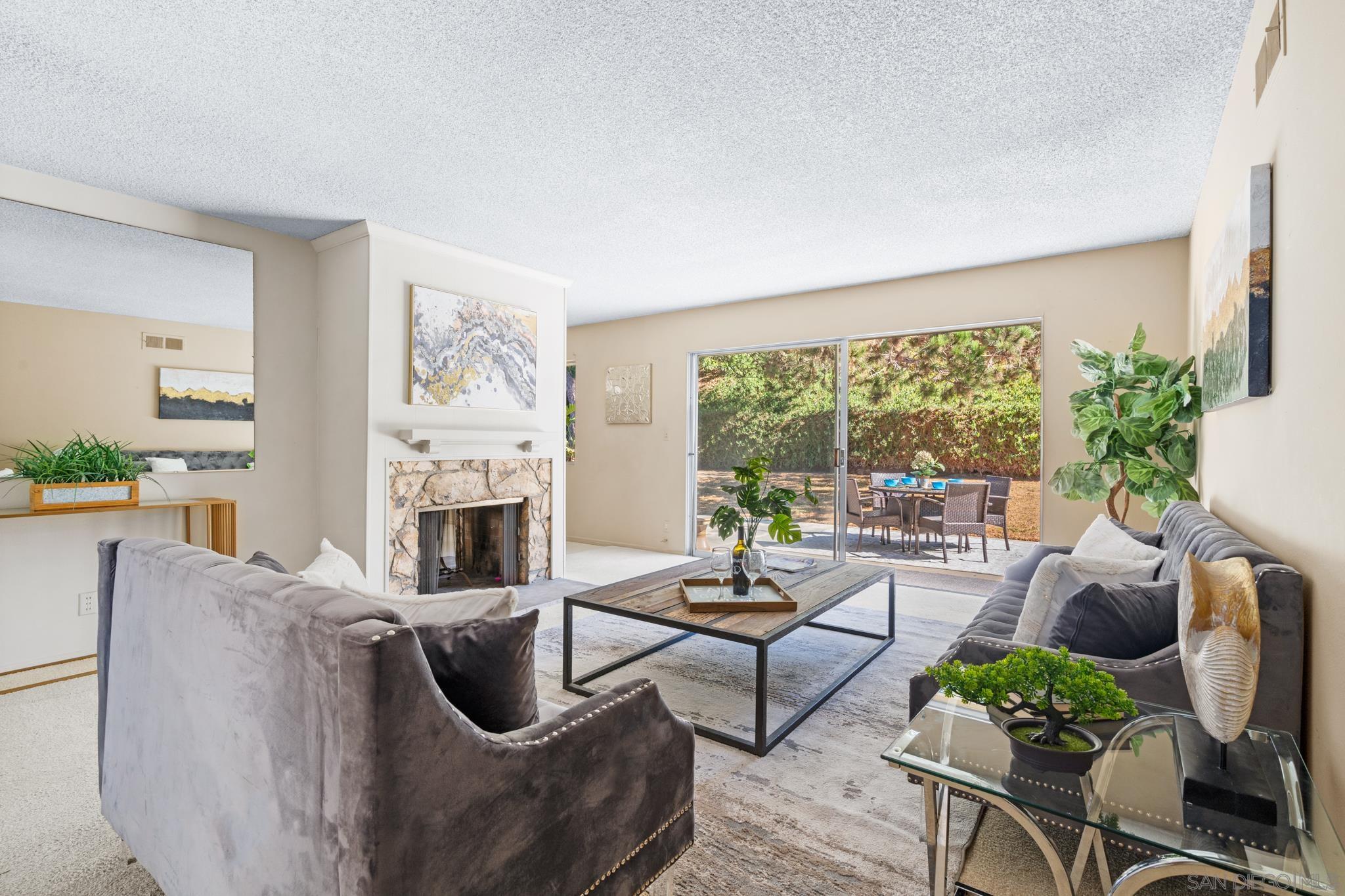 a living room with furniture a fireplace and a large window