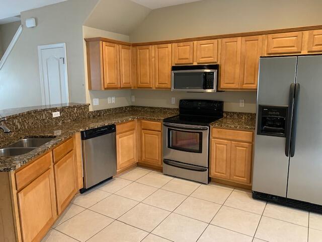 a kitchen with granite countertop a sink a stove top oven and stainless steel appliances