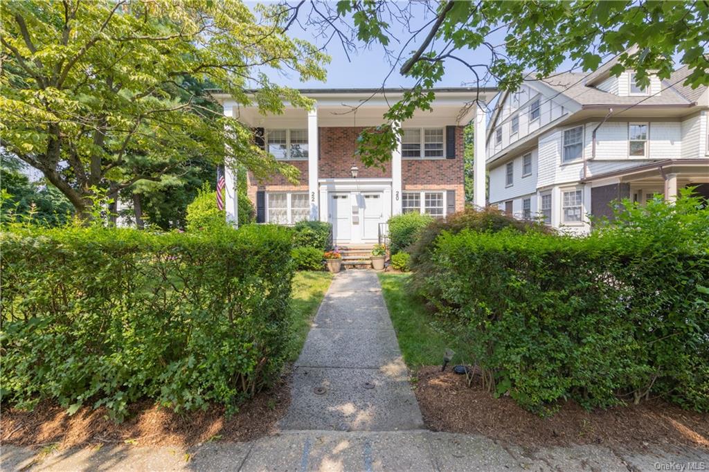 front view of a brick house with a yard