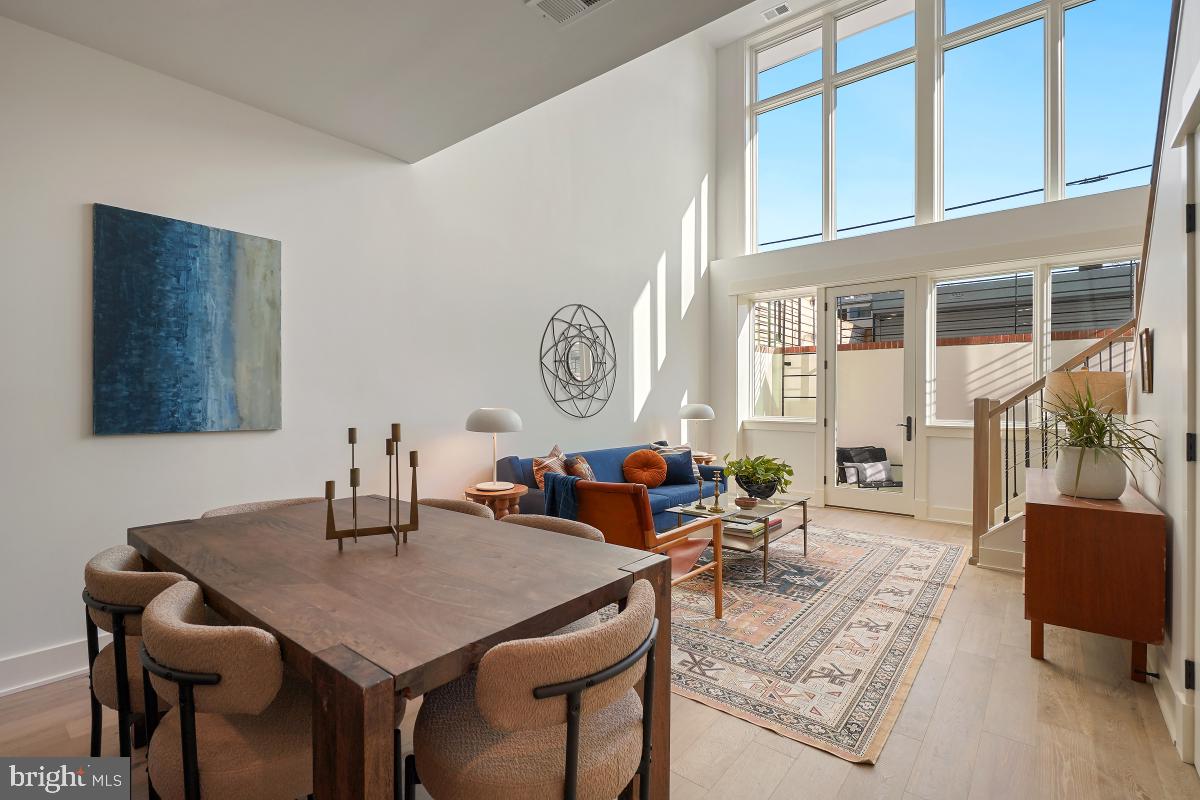 a living room with furniture a clock and a large window