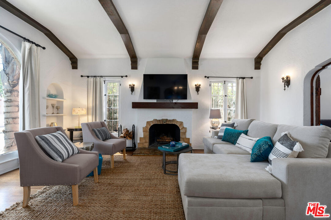 a living room with furniture a flat screen tv and a fireplace