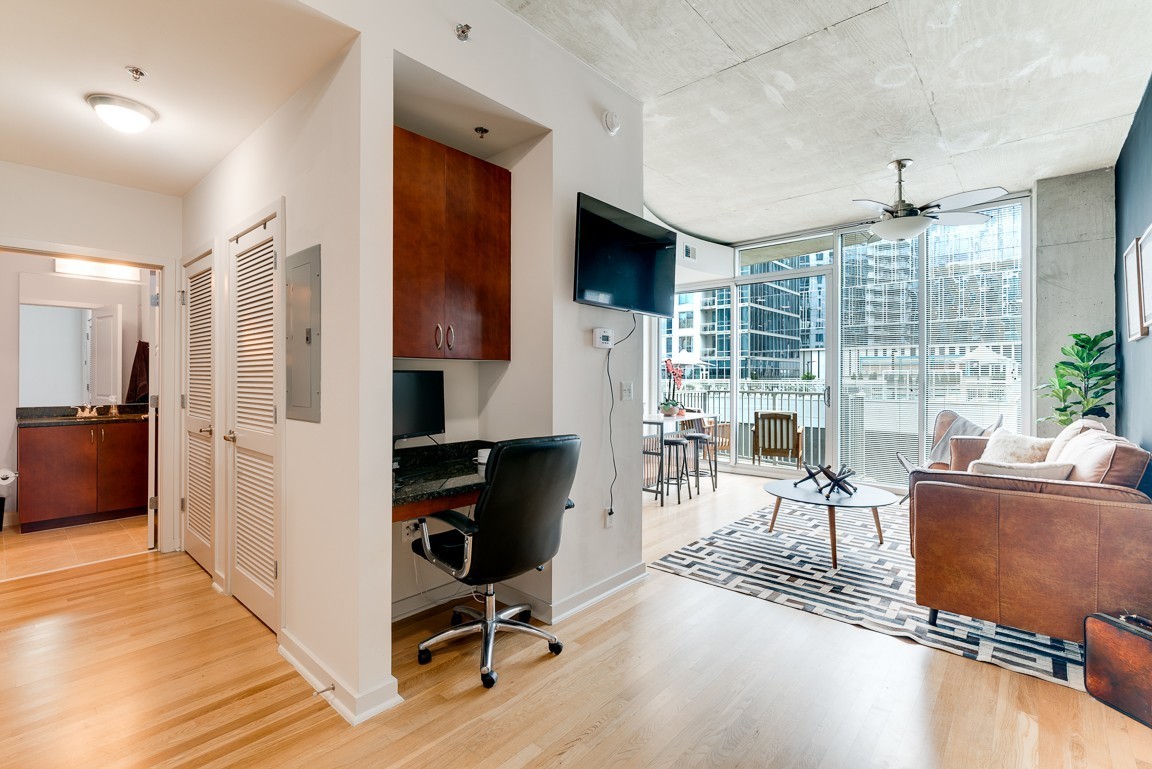 a living room with furniture large window and wooden floor