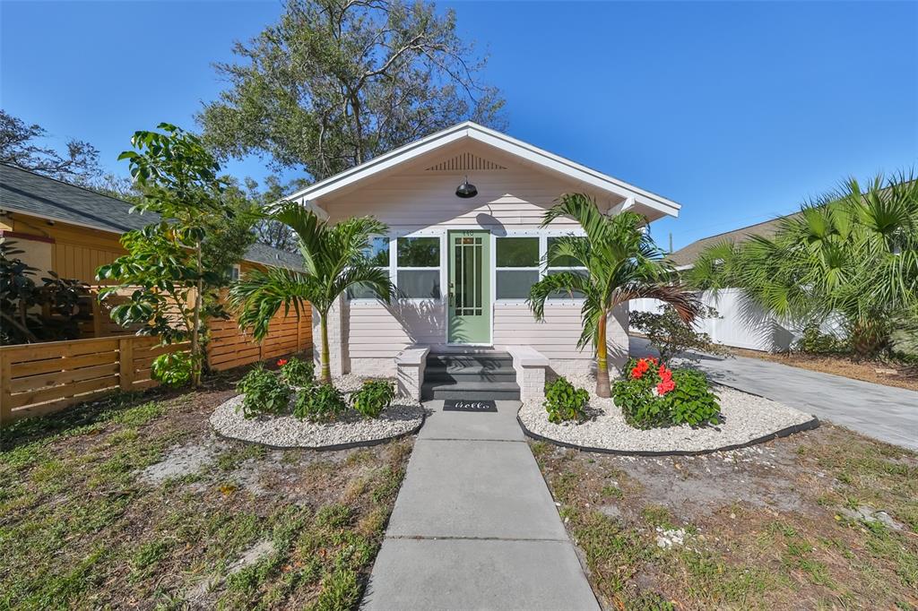 a front view of a house with a yard and potted plants