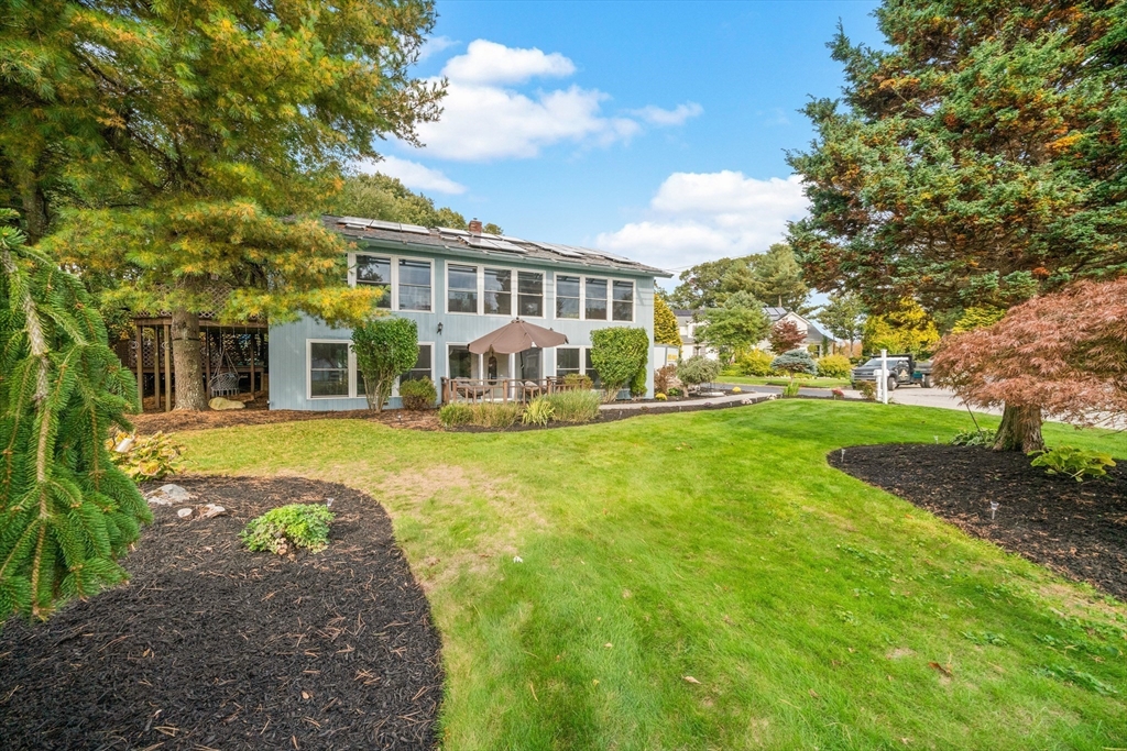 a view of a house with a big yard and large trees