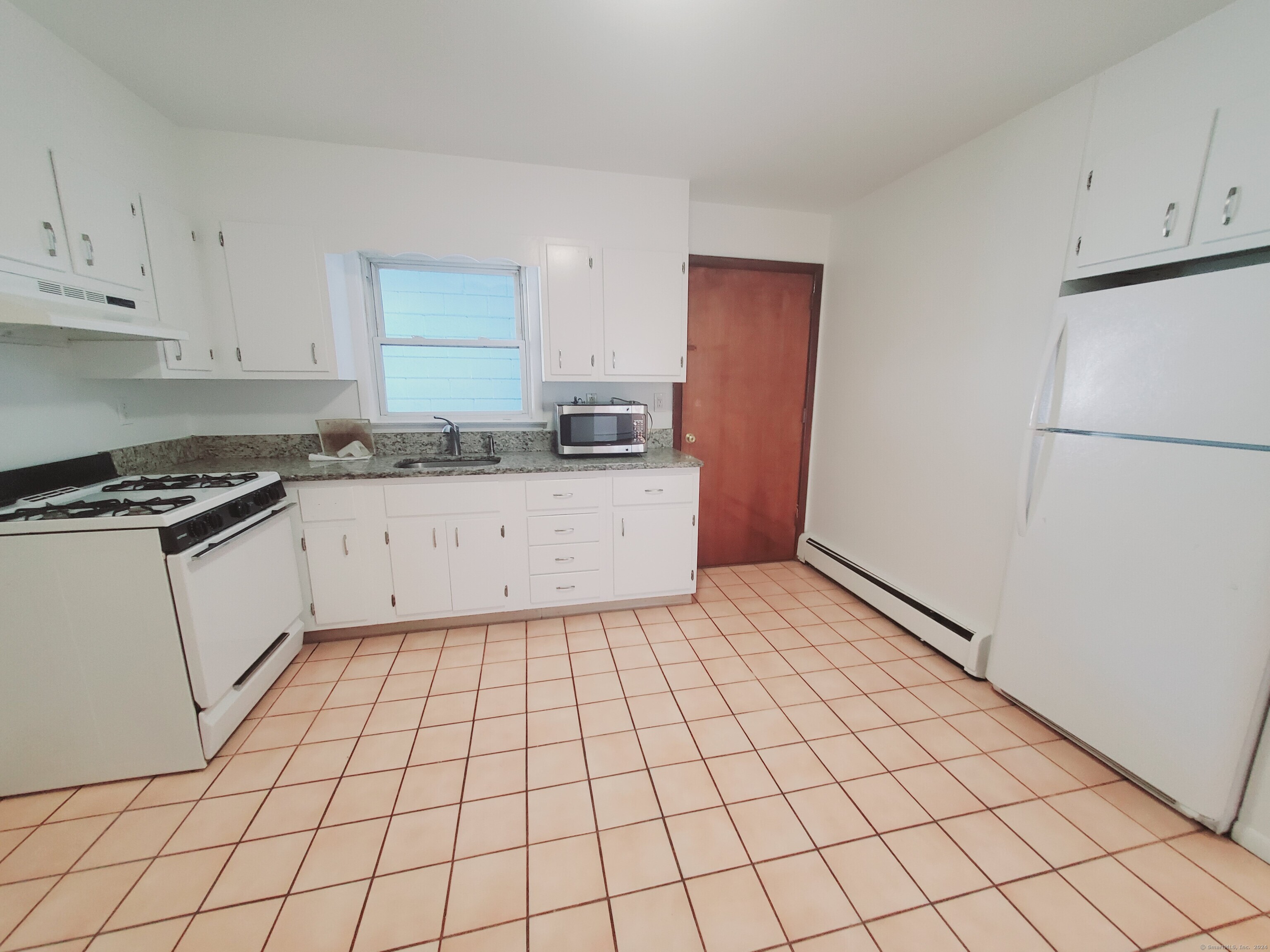 a kitchen with a sink a stove cabinets and counter space