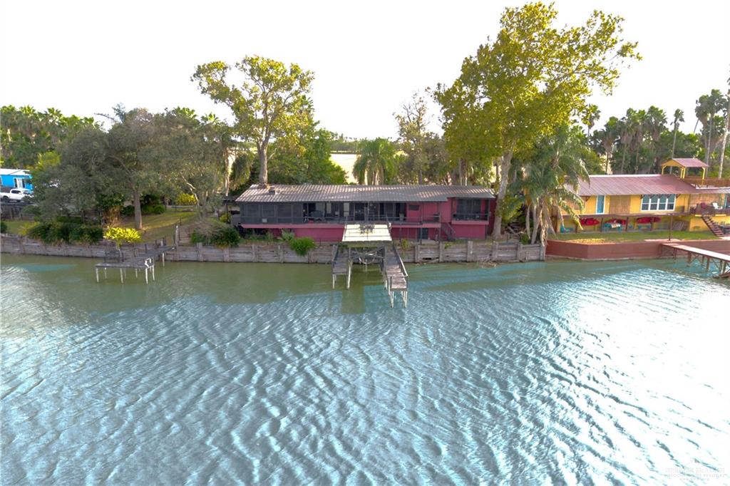 View of house with water front and boat dock/lift