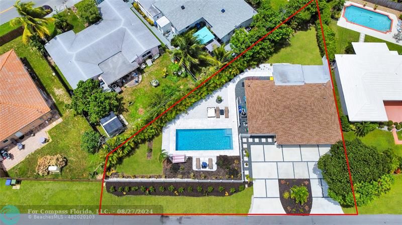 an aerial view of a house with a yard and large trees