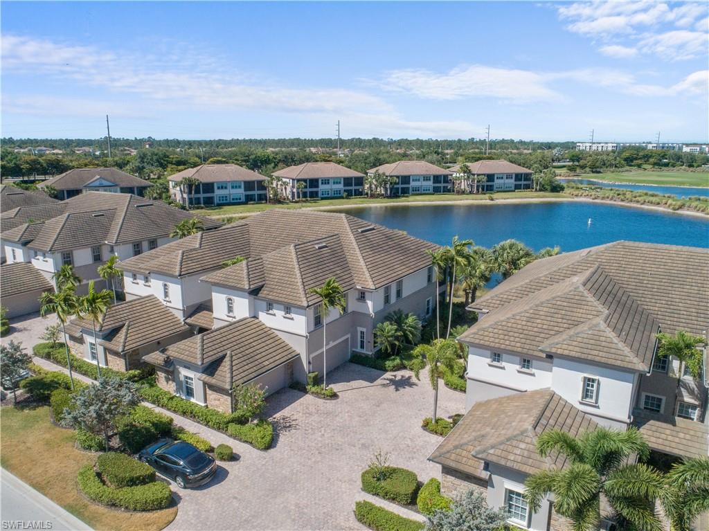 an aerial view of a house with outdoor space and lake view in back