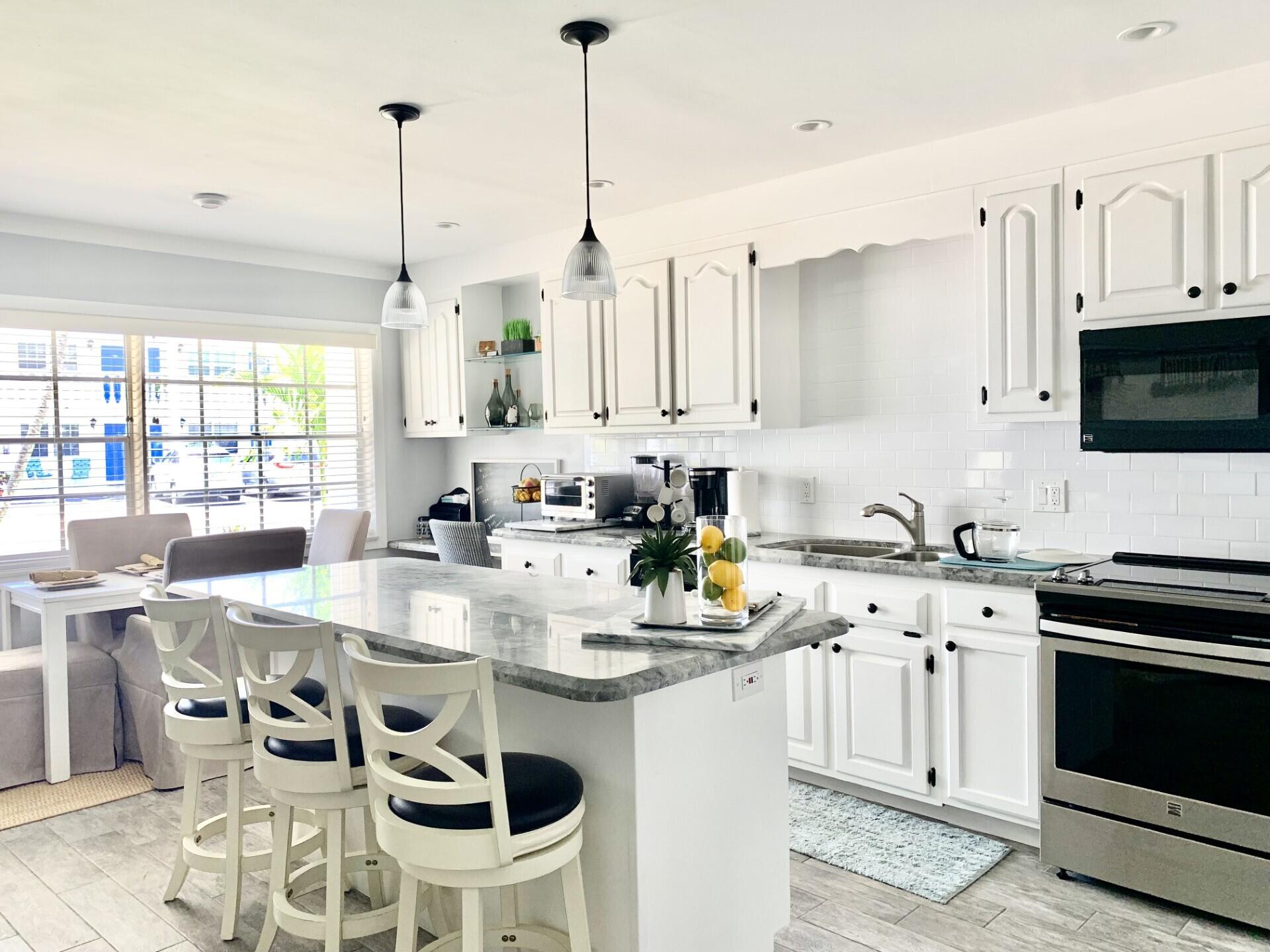 a kitchen with appliances a stove a table and chairs