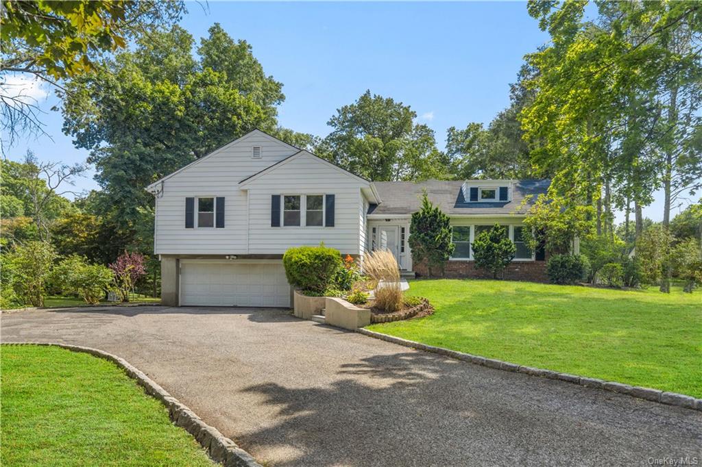 a front view of a house with a garden and yard