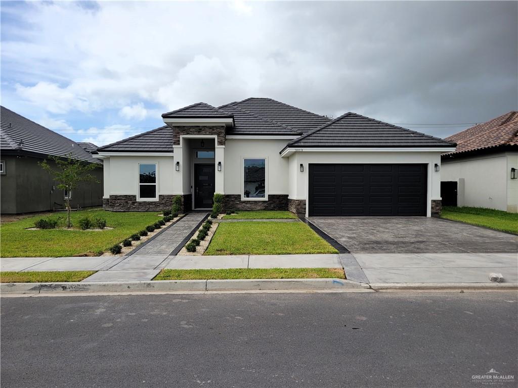 a front view of a house with a yard and garage