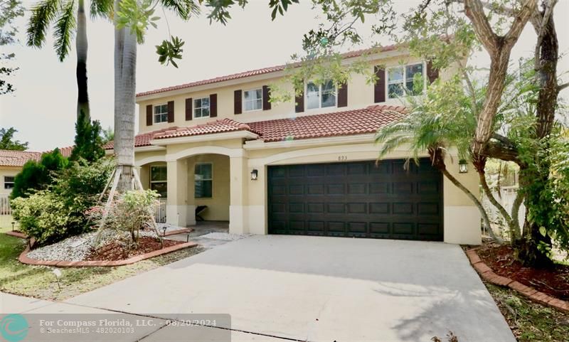 a front view of a house with a yard and a garage