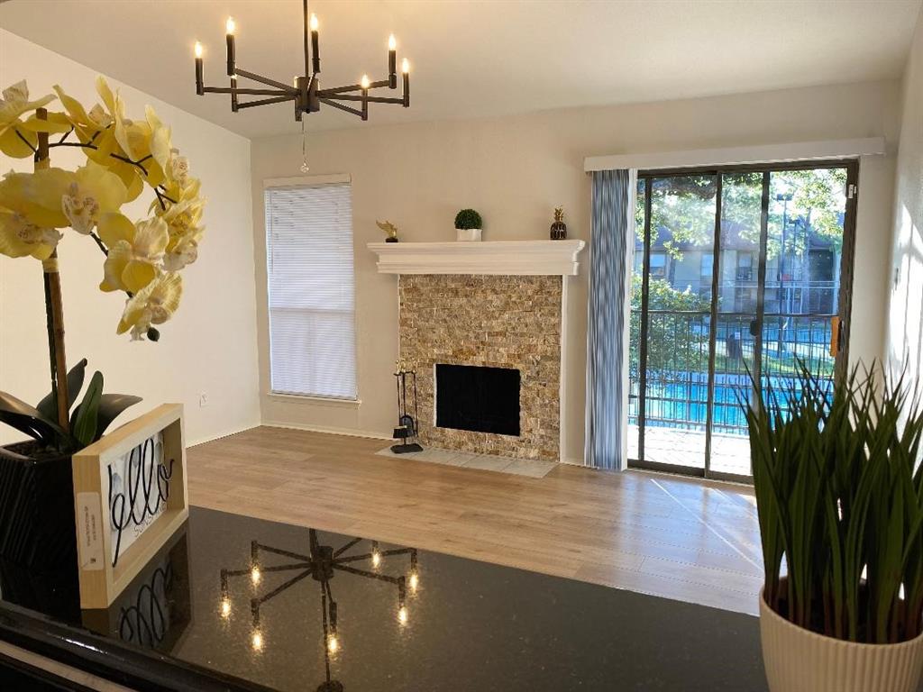 a view of an empty room with a fireplace and wooden floor