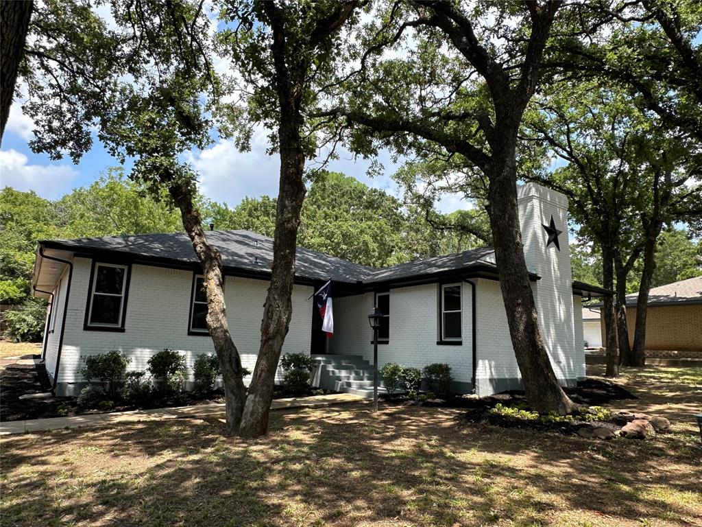 a view of a house with backyard and trees