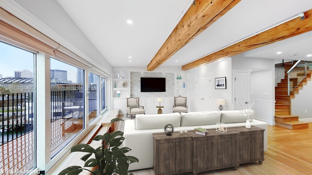 a living room with furniture wooden floor and a large window