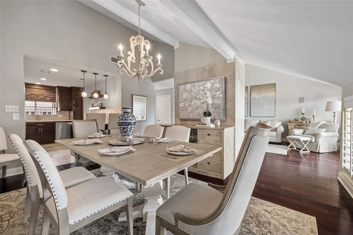 a view of a dining room with furniture a chandelier and wooden floor