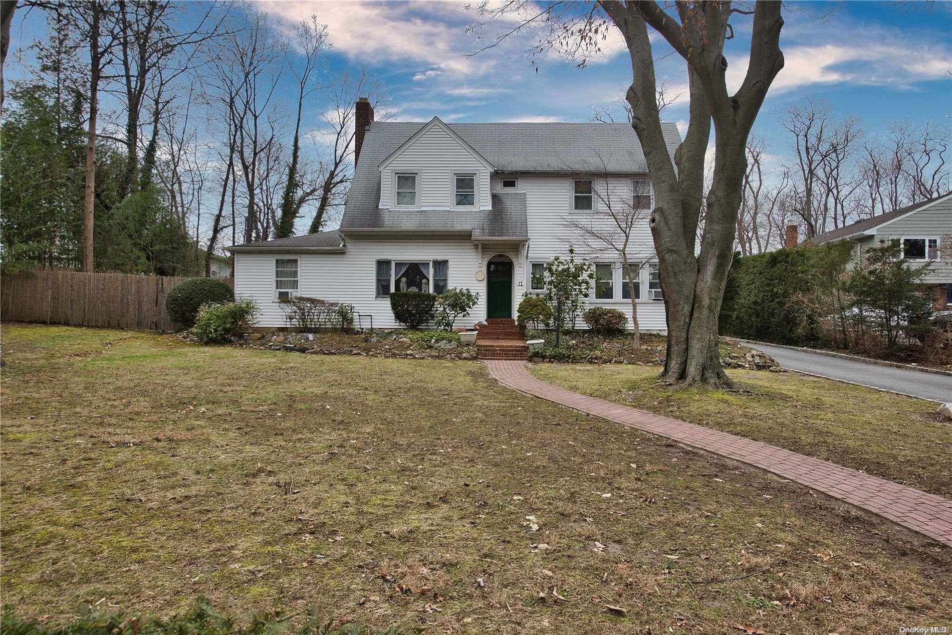 a view of house with yard and trees in the background