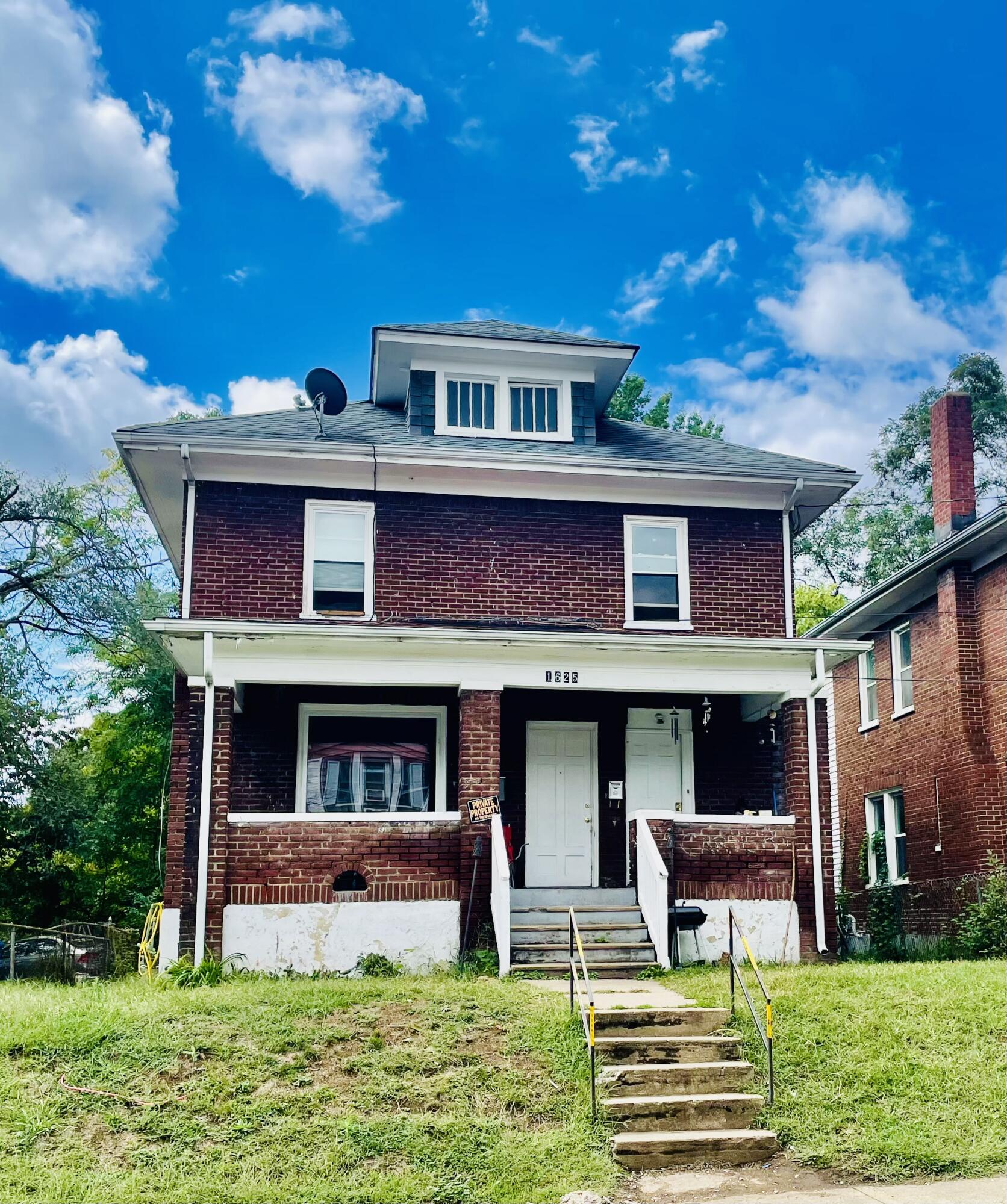 a view of front of a brick building with a yard