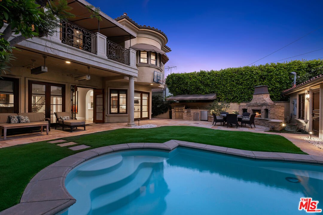 a front view of a house with swimming pool having outdoor seating