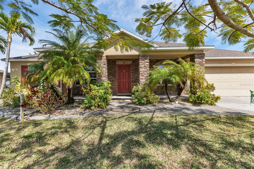 Front of home shaded by mature royal poinciana tree 