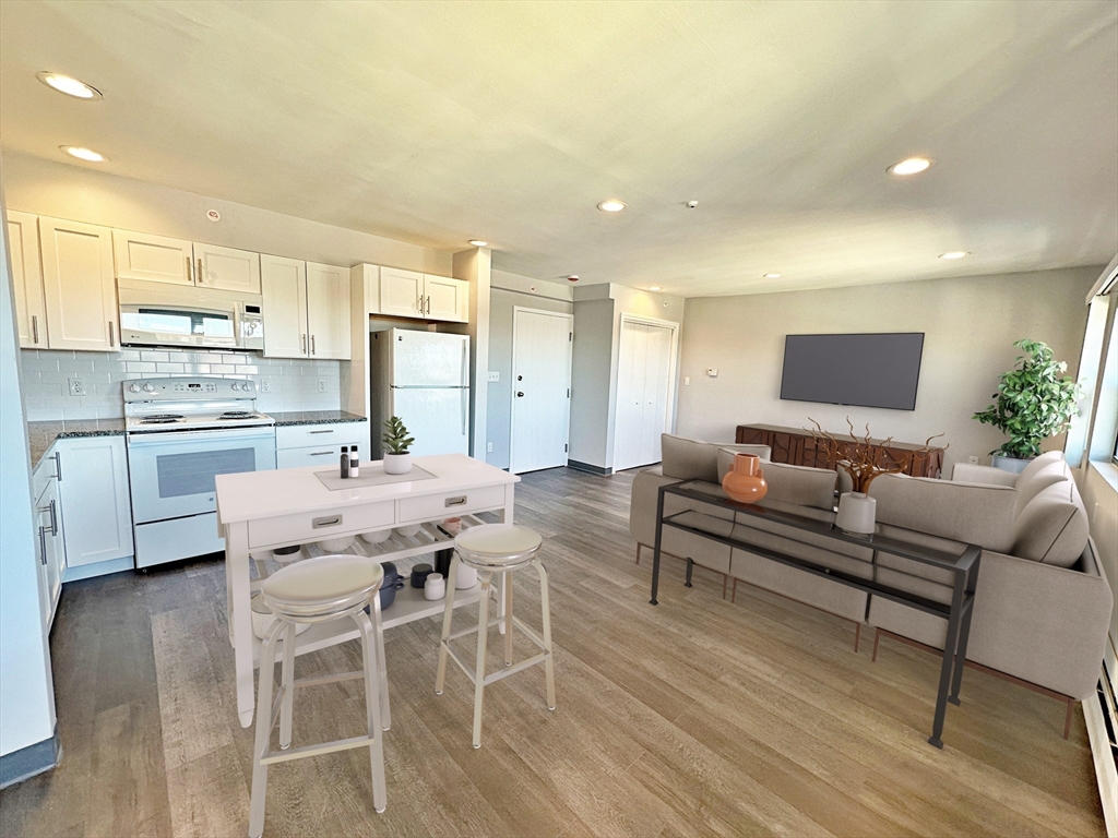 a living room with stainless steel appliances kitchen island granite countertop furniture and a kitchen view