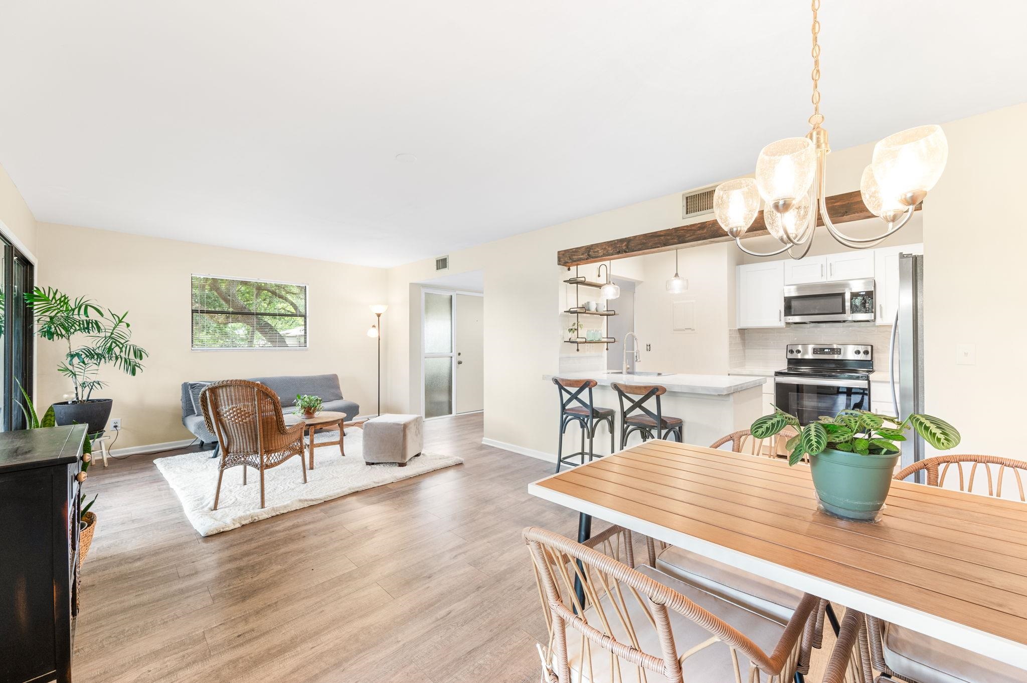 a dining room with wooden floor a chandelier a wooden table and chairs