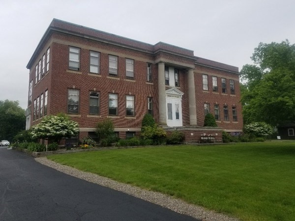 a front view of a house with a garden and yard