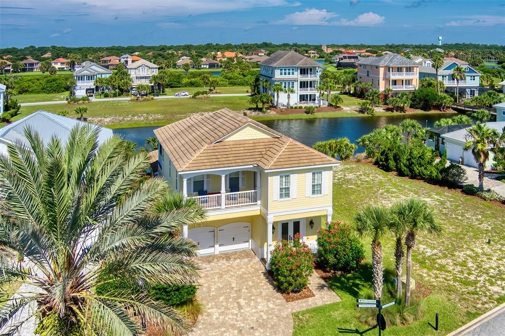 an aerial view of a house with a garden and lake view