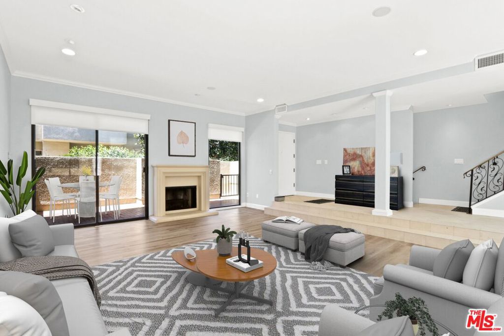 a living room with furniture fireplace and a large window