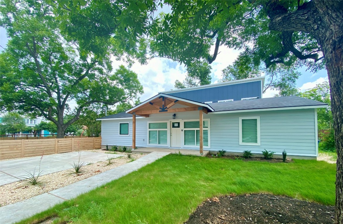 a front view of a house with a garden and yard