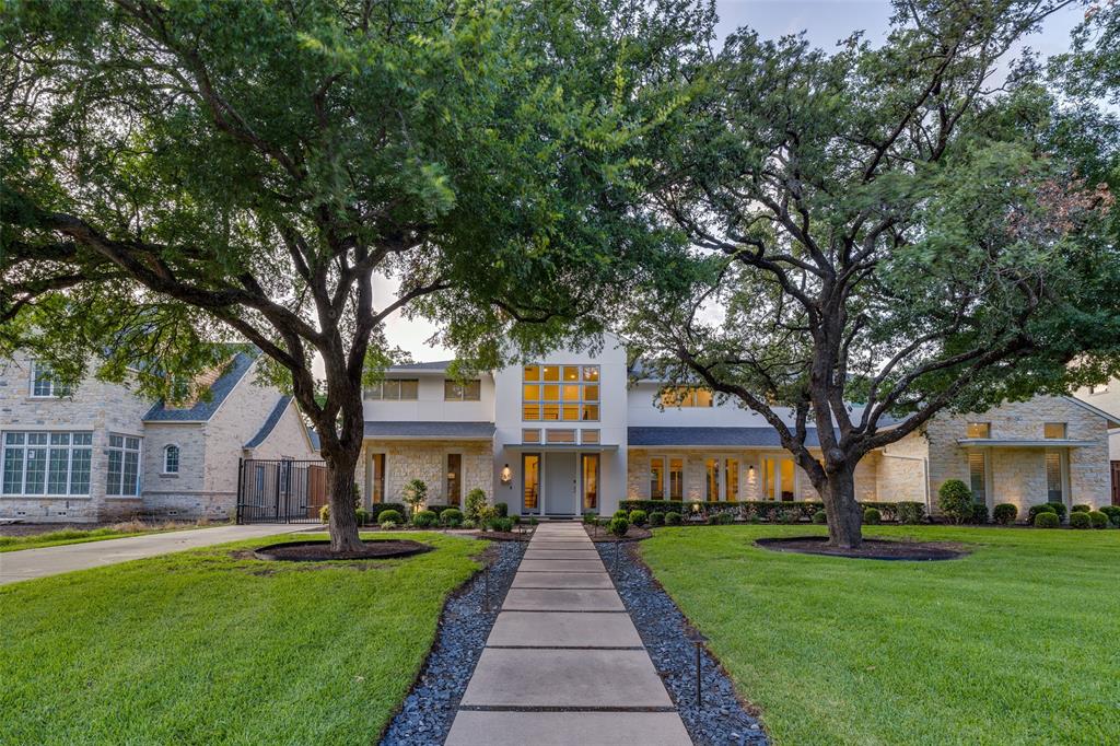 a front view of a house with a garden and trees