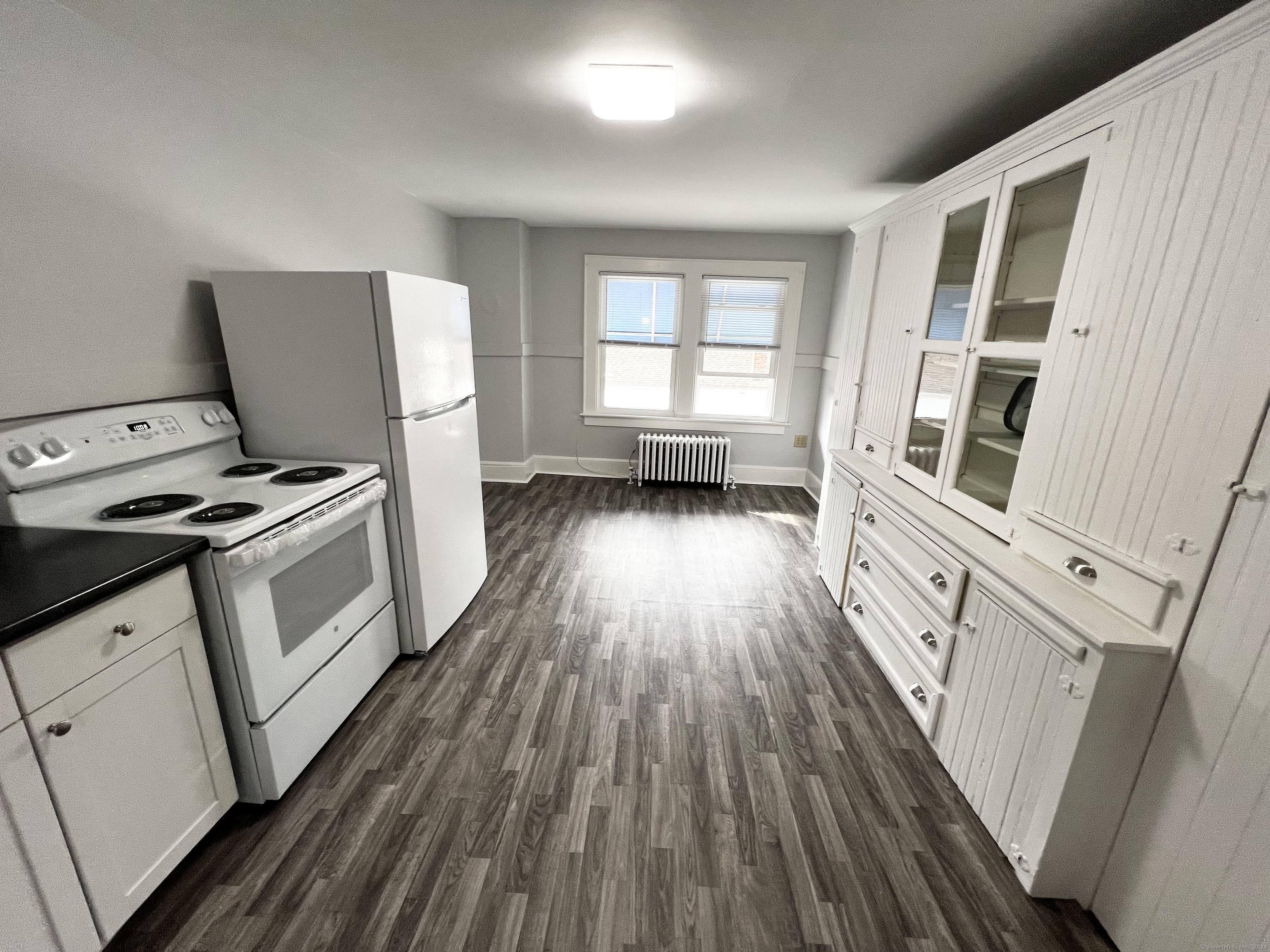 a kitchen with wooden floors and white appliances