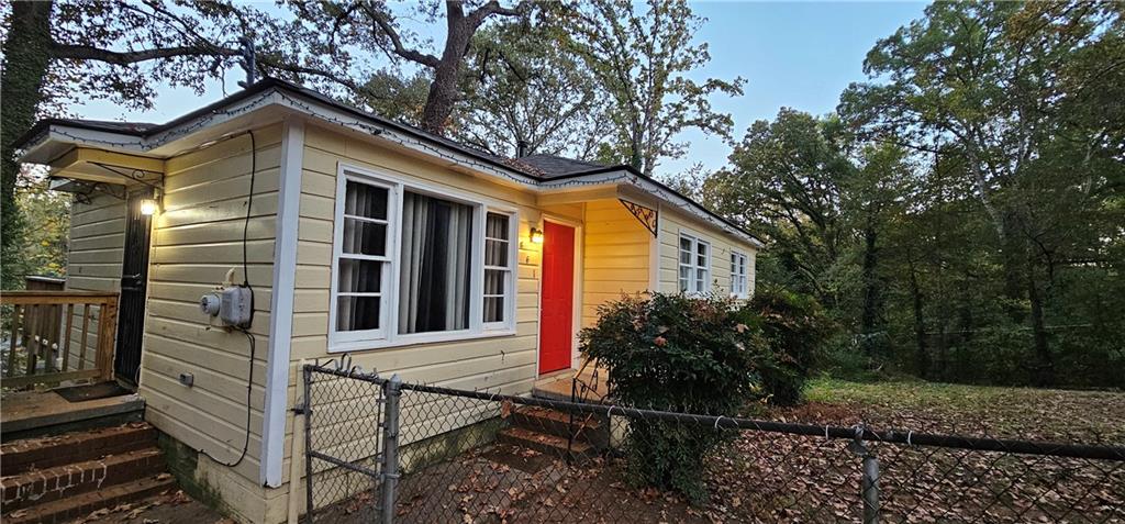 a view of house with backyard and trees