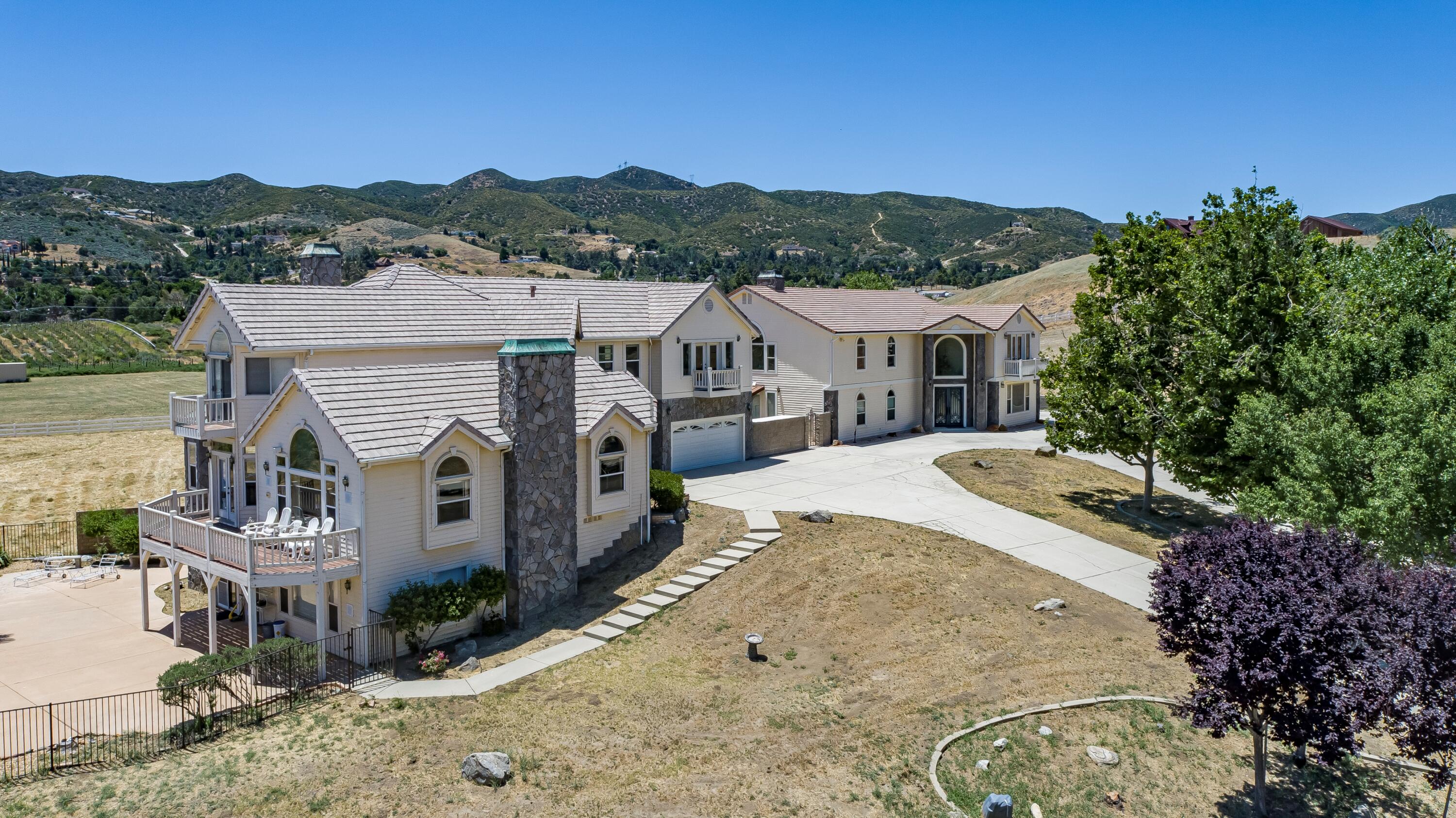 an aerial view of a house with a garden and mountains