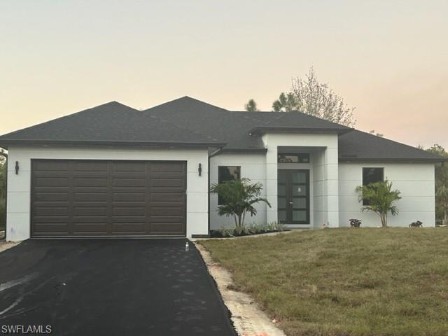 View of front of home with a yard and a garage