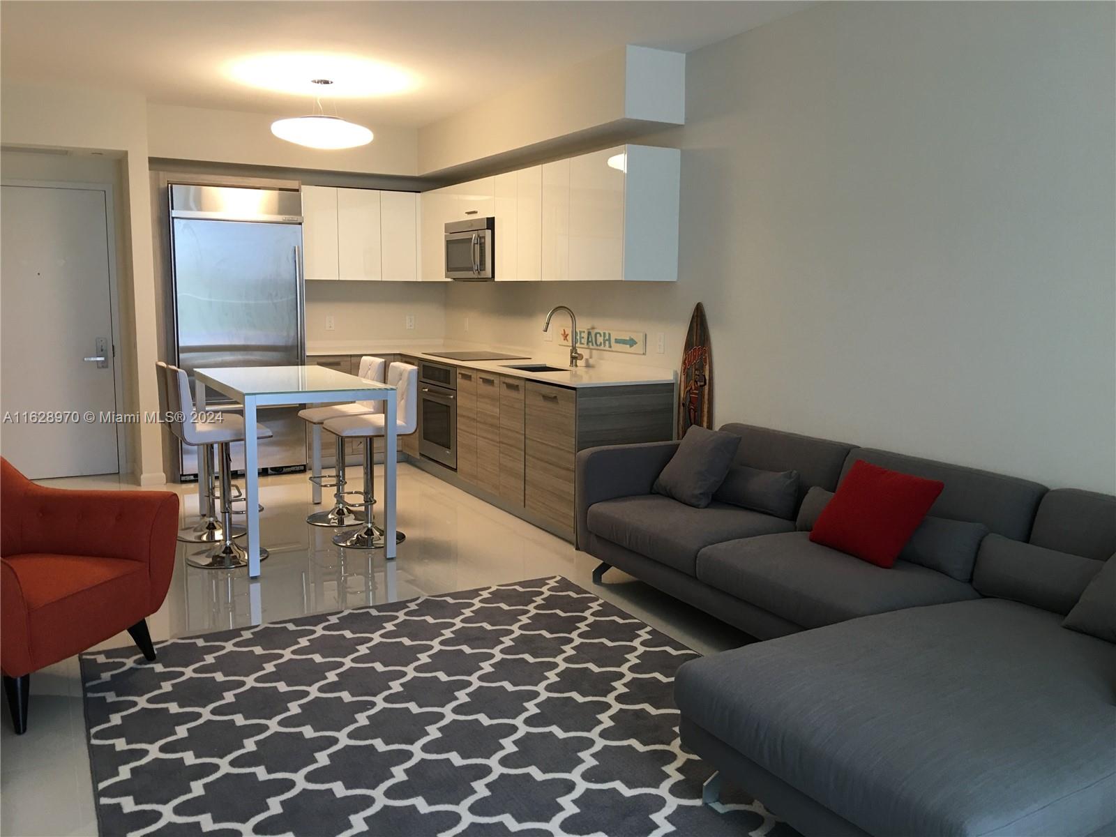 a living room with a couch and a view of kitchen