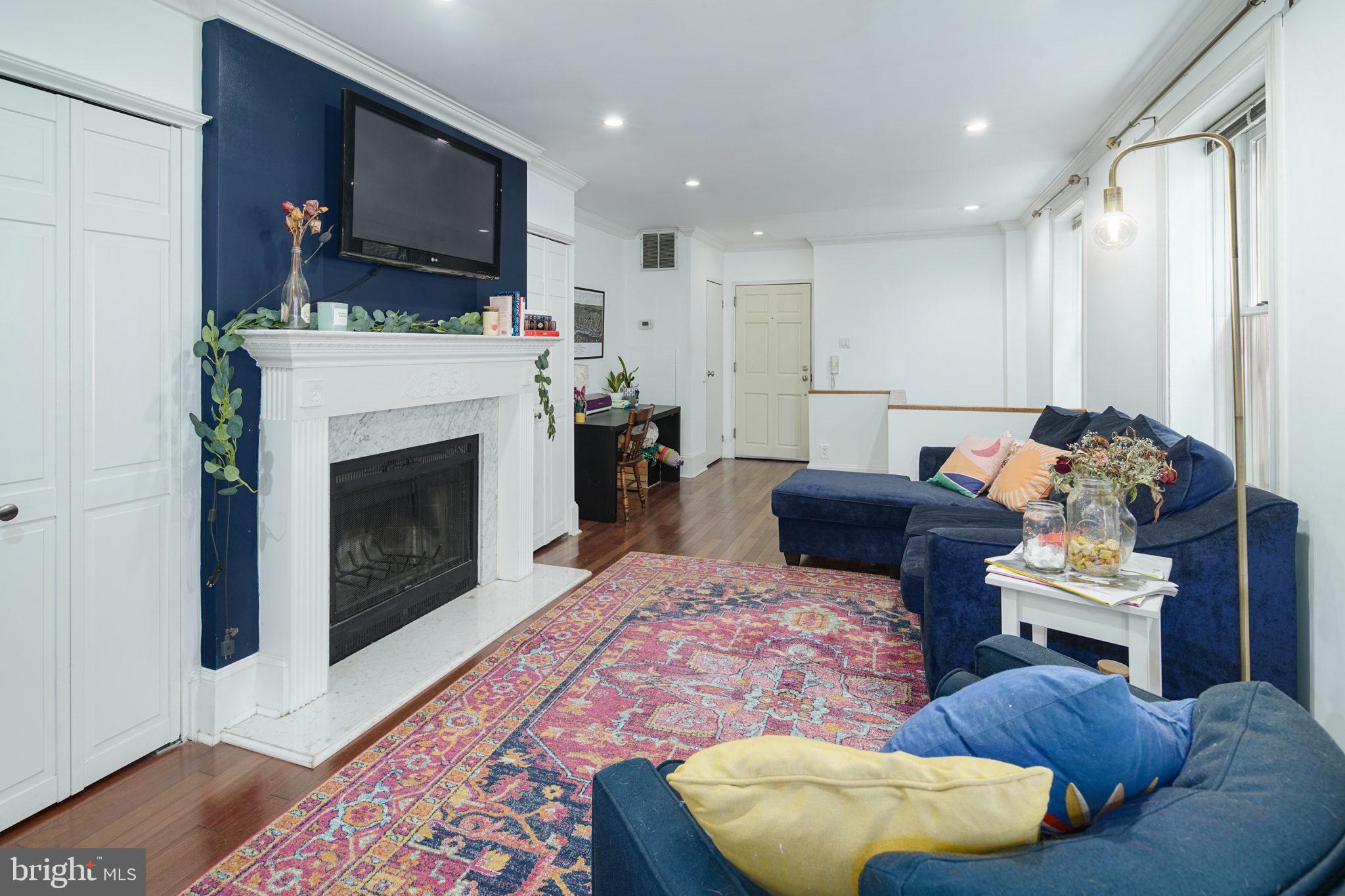 a living room with furniture a flat screen tv and a fireplace