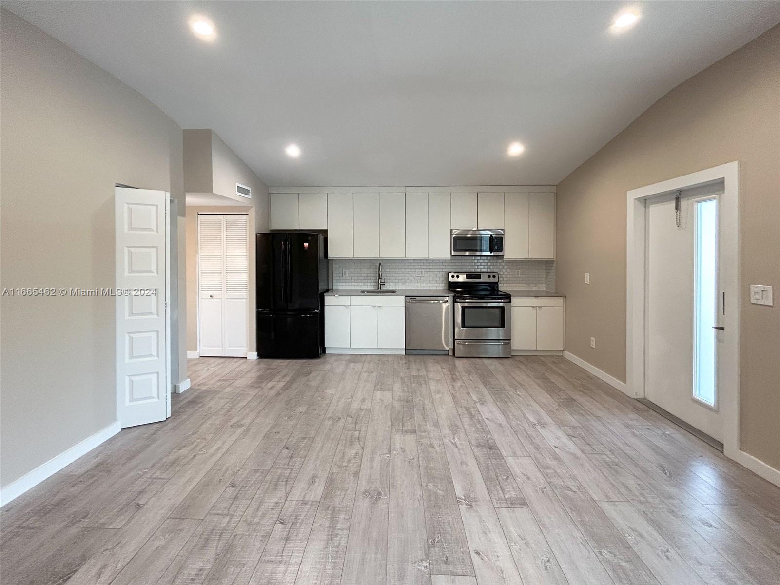 a view of kitchen with refrigerator microwave and wooden floor