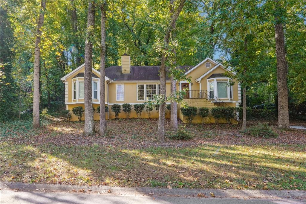 a front view of a house with a yard and trees