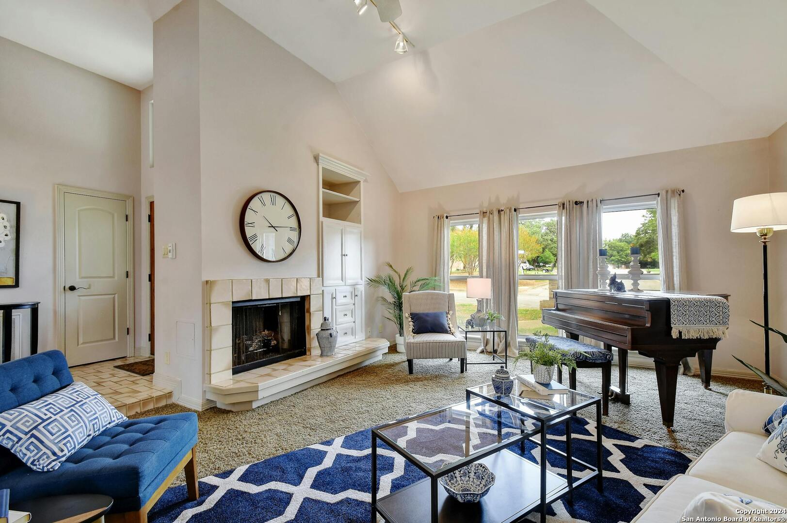 a living room with furniture a fireplace a rug and a window