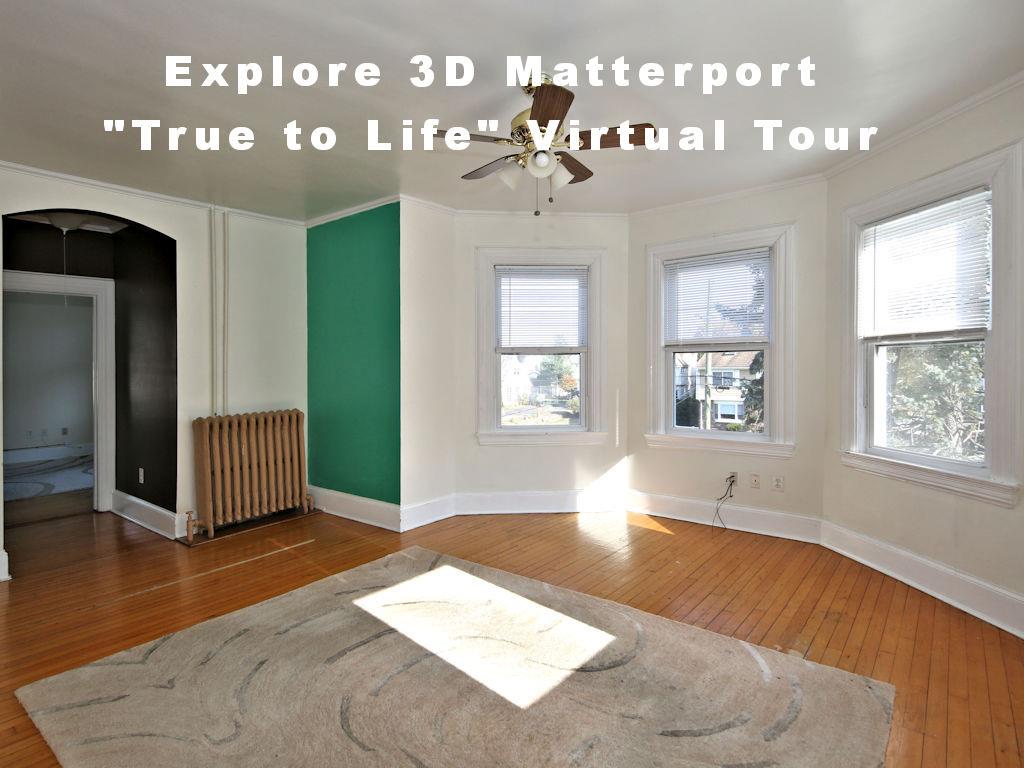 Empty room with a wealth of natural light, hardwood / wood-style flooring, and radiator