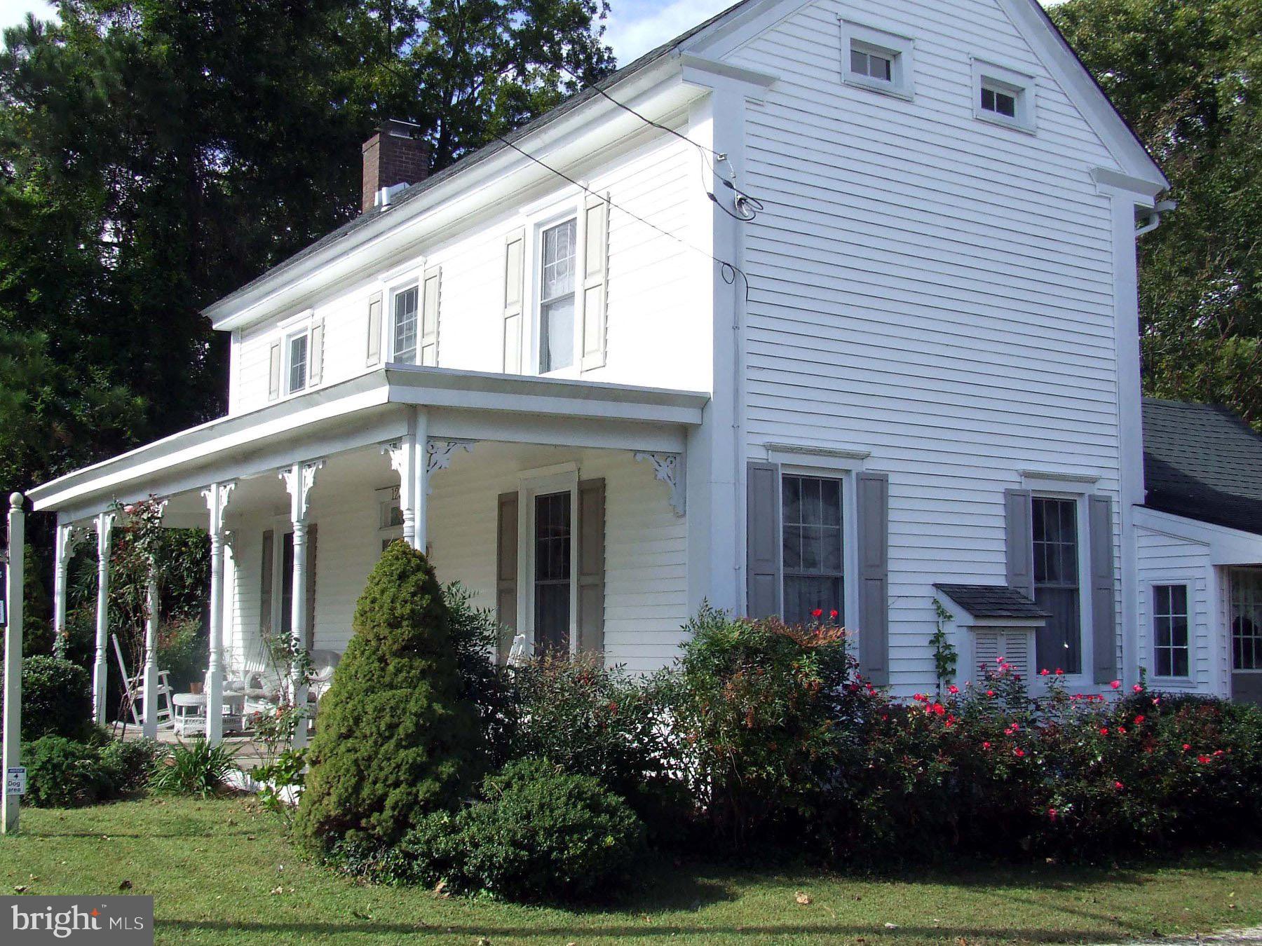 a front view of a house with a yard and potted plants