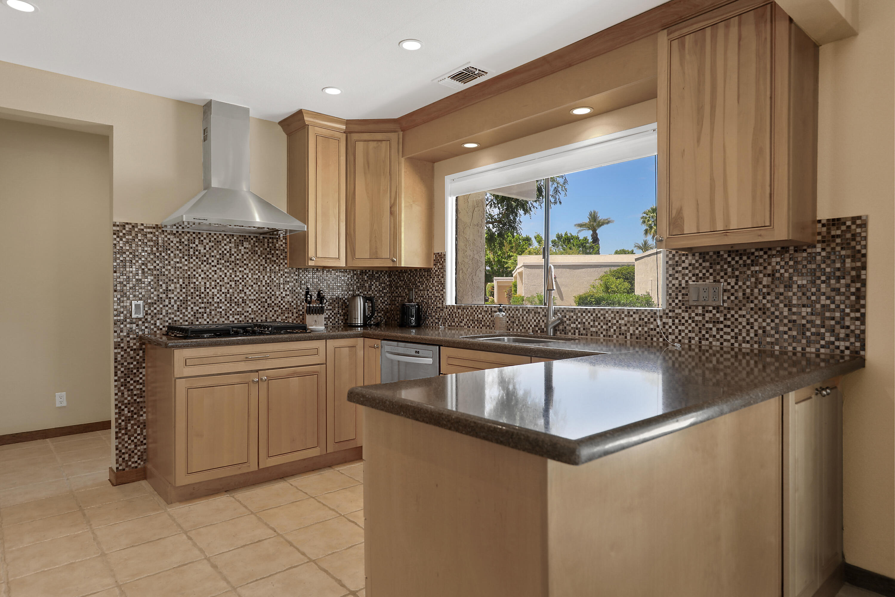 a kitchen with granite countertop a sink a stove and a microwave