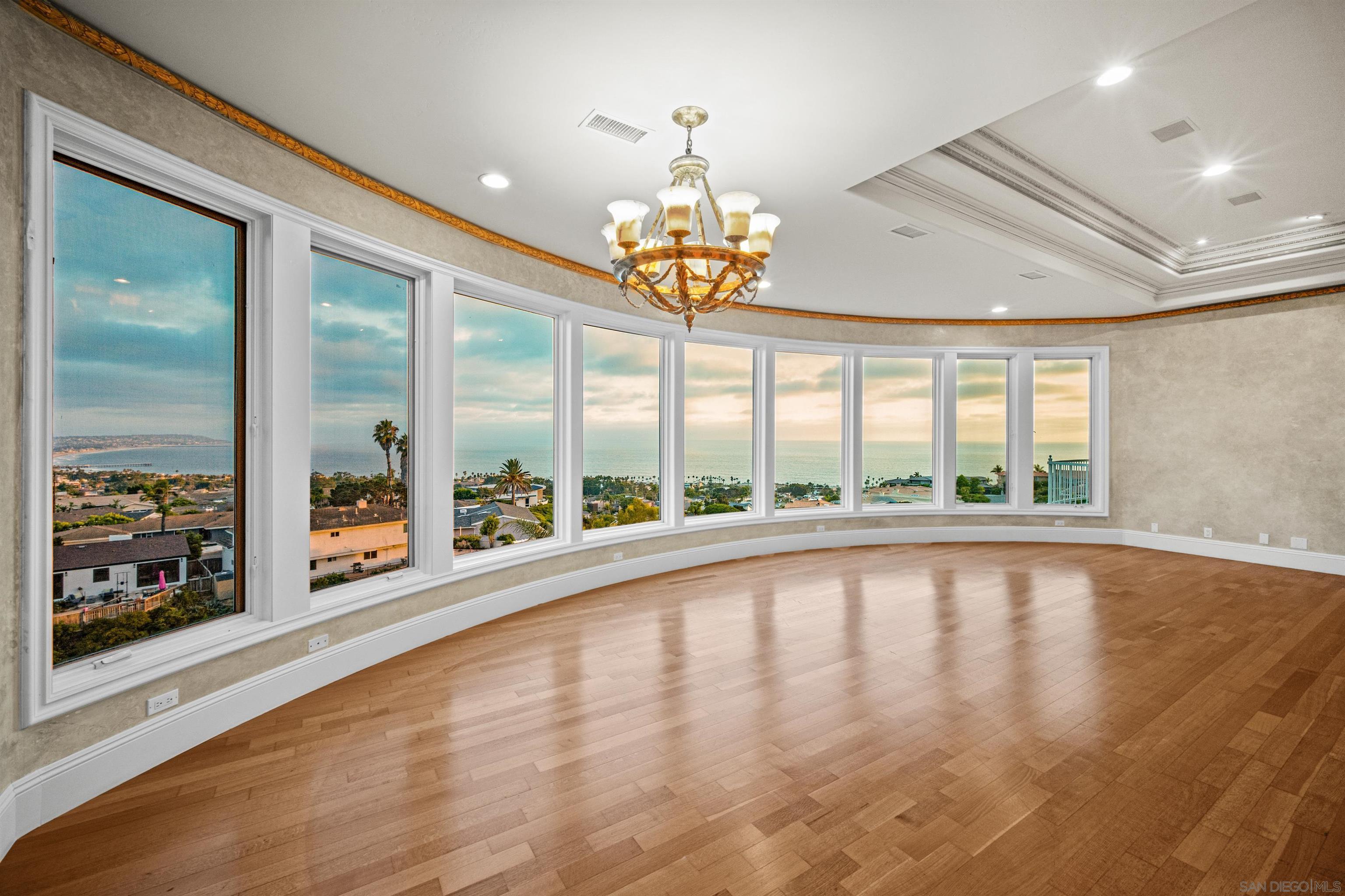 a view of a room with wooden floor and large windows