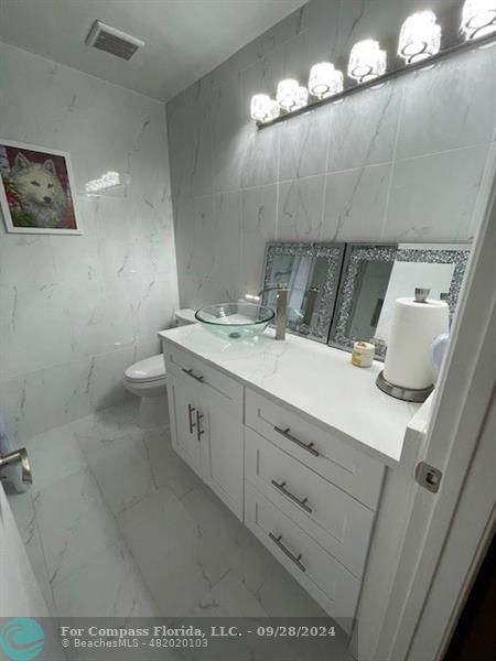 a bathroom with a sink a light fixture and a toilet