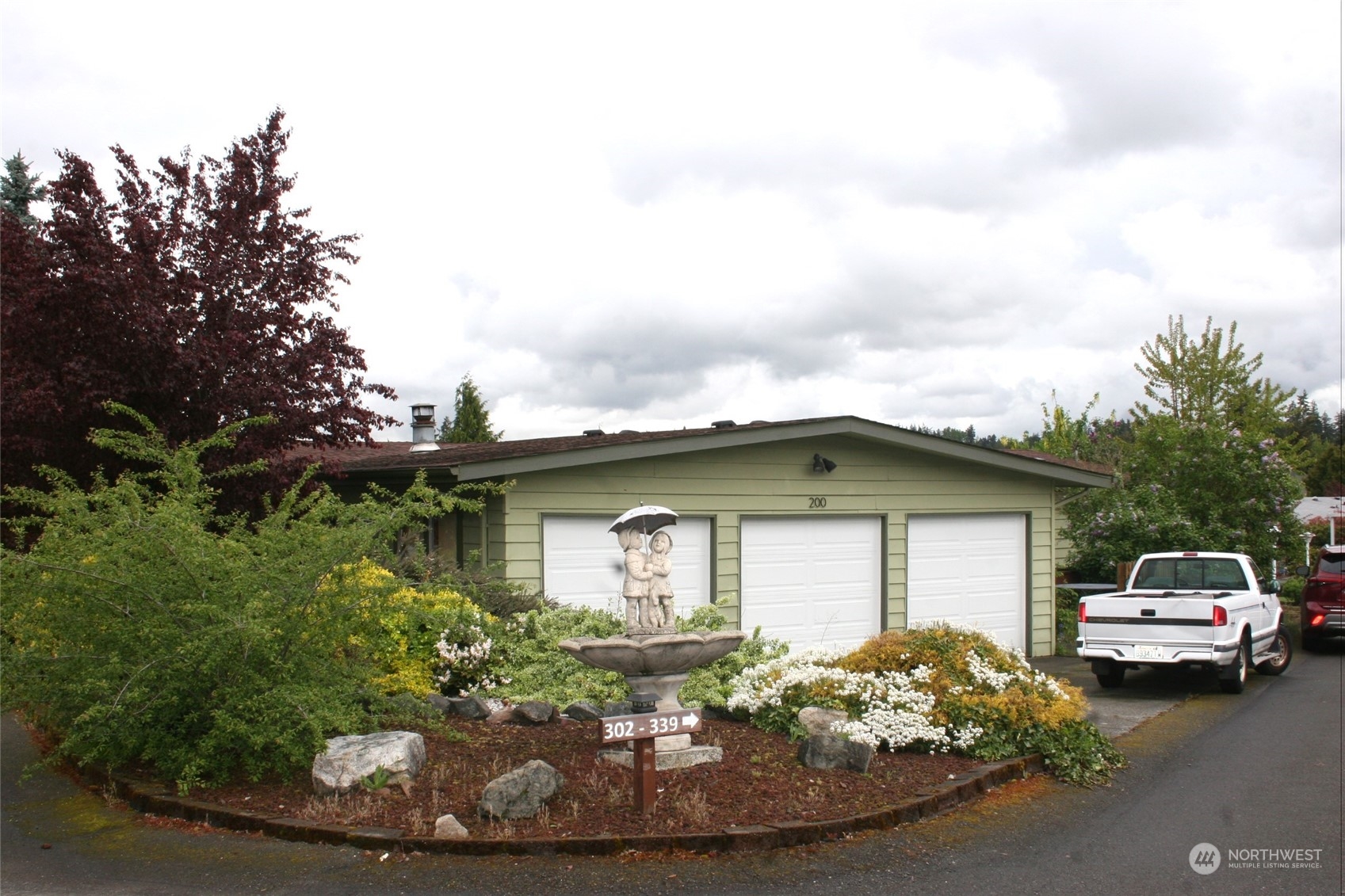 a front view of a house with a garden