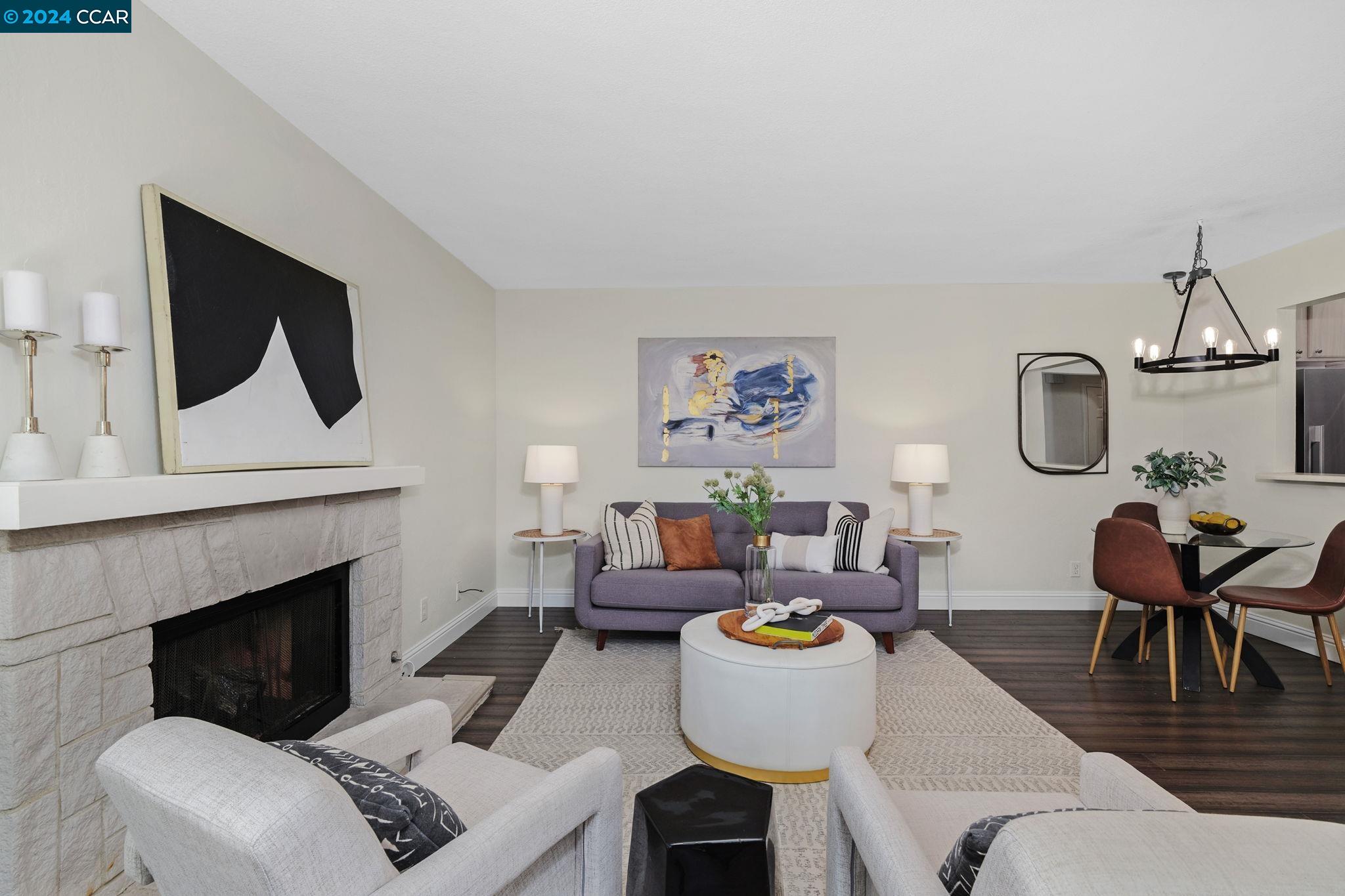 a living room with furniture a fireplace and wall paintings