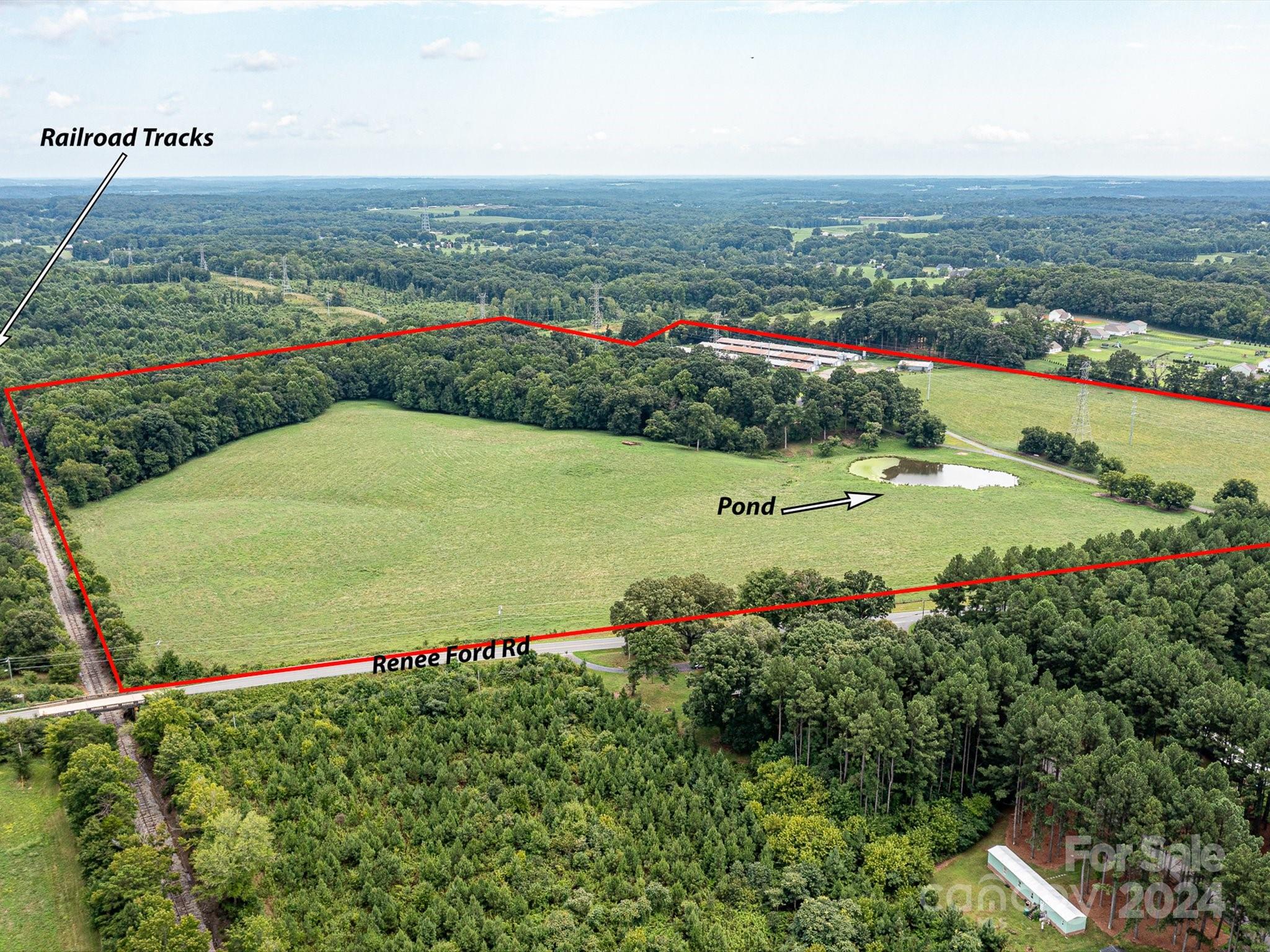 an aerial view of a houses with a yard and lake view