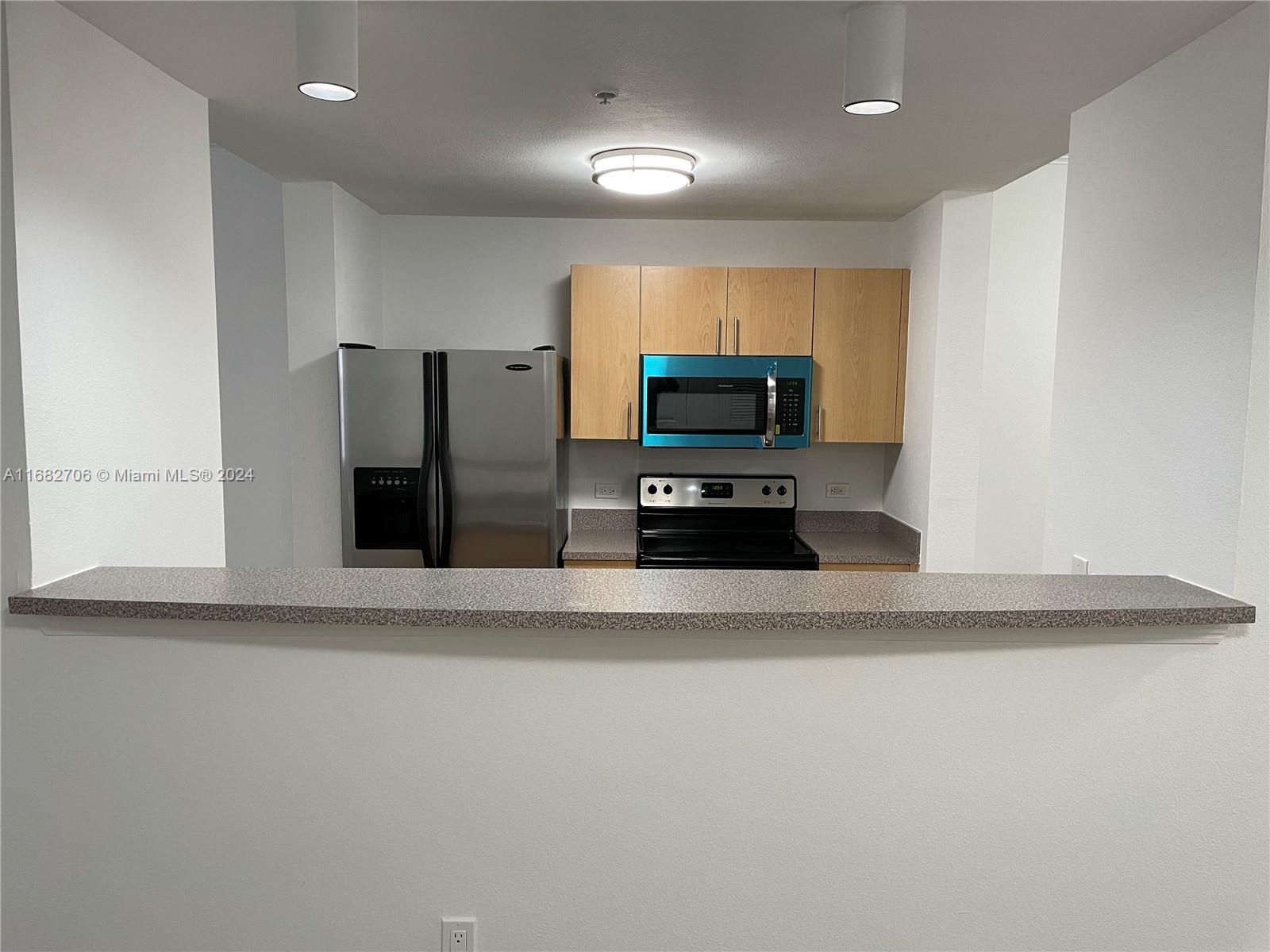 a kitchen with stainless steel appliances a refrigerator microwave and stove